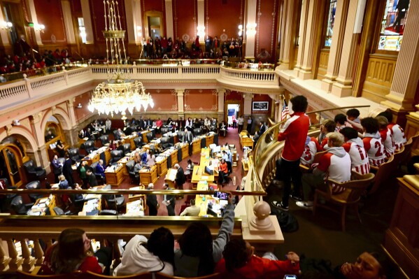 FILE - Members of Denver's East High School soccer team, right, sit in the house chamber at the Colorado Capitol in Denver after walking out of classes March 3, 2023, to push for legislative action after a fellow student was shot and killed near the school on Feb. 13. Colorado will join at least 10 other states Sunday, Oct. 1, when a law takes effect that requires a waiting period between purchasing a gun and receiving it. The three-day buffer is aimed at curtailing rash suicide attempts or violence. Another law that taking effect will expand gun industry liability, opening the doors to lawsuits from gun violence victims. (Andy Cross/The Denver Post via AP, File)
