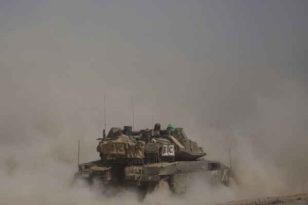 Israeli soldiers move tanks around staging area near the border with the Gaza Strip, in southern Israel, Sunday, May 18, 2025. (AP Photo/Ariel Schalit)