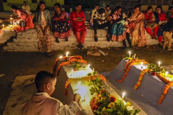 Christian families remember their loved ones by lighting candles and putting flowers on their graves early morning on Easter in Purulia, West Bengal, India, Sunday, March 31, 2024. Christian around the world are celebrating Easter commemorating the day when according to Christian tradition Jesus was resurrected in Jerusalem two millennia ago. (AP Photo/Bikas Das)
