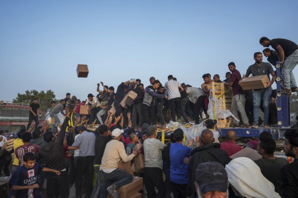 FILE - Palestinians are storming trucks loaded with humanitarian aid brought in through a new U.S.-built pier, in the central Gaza Strip, Saturday, May 18, 2024. United Nations agencies are warning, Wednesday, June 5, that over 1 million Palestinians in the Gaza Strip could experience the highest level of life-threatening starvation by the middle of next month if hostilities continue. (AP Photo/Abdel Kareem Hana, File)