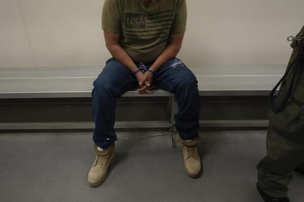 FILE - An immigrant considered a threat to public safety and national security waits to be processed by U.S. Immigration and Customs Enforcement agents at the ICE Metropolitan Detention Center in Los Angeles, after an early morning raid, June 6, 2022. The Supreme Court is taking up a dispute over a blocked Biden administration policy that would prioritize deportation of people in the country illegally who pose the greatest public safety risk. (AP Photo/Damian Dovarganes, File)