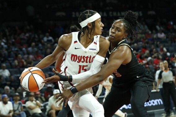 Washington Mystics guard Brittney Sykes (15) is covered by Las Vegas Aces guard Chelsea Gray, right, during the first half of a WNBA basketball game Friday, Aug. 11, 2023, in Las Vegas. (Steve Marcus/Las Vegas Sun via AP)