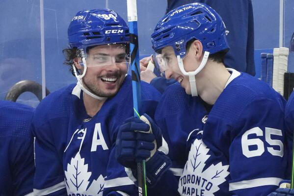 Toronto Maple Leafs forward Auston Matthews (34) smiles with teammate Ilya Mikheyev (65) after after scoring his hat trick during third-period NHL hockey game action against the New Jersey Devils in Toronto, Monday, Jan. 31, 2022. (Nathan Denette/The Canadian Press via AP)Canadian Press via AP)