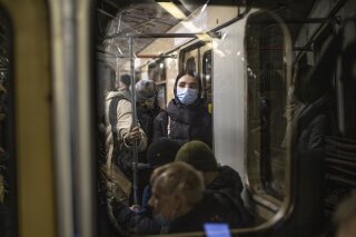 A woman wearing a face mask to help curb the spread of the coronavirus rides a subway car in Moscow, Russia, Monday, Jan. 11, 2021. Russia has continued to face high numbers of new infections even as it has launched a mass vaccination effort. (AP Photo/Alexander Zemlianichenko)