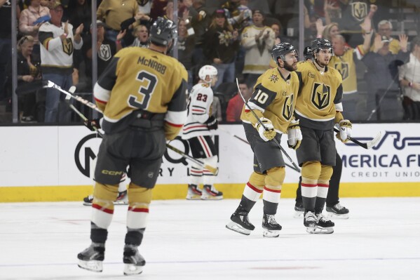 Vegas Golden Knights centers Nicolas Roy (10) and Brett Howden (21) celebrate Roy's goal against the Chicago Blackhawks during the third period of an NHL hockey game Tuesday, April 16, 2024, in Las Vegas. (AP Photo/Ian Maule)