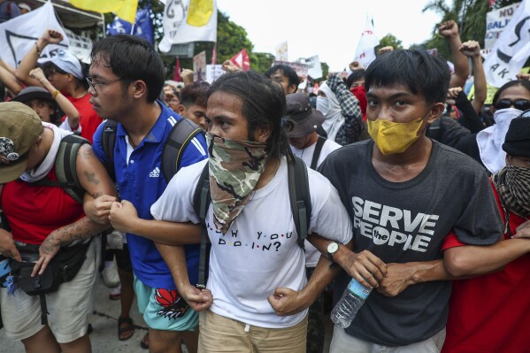 Philippinische Aktivisten marschieren am Mittwoch, dem 1. Mai 2024, während eines Protestes zum Internationalen Tag der Arbeit in Manila, Philippinen, in Richtung der US-Botschaft. Hunderte philippinische Arbeiter verschiedener Gewerkschaftsgruppen gingen auf die Straße, um den Tag der Arbeit zu feiern und höhere Löhne und Möglichkeiten für eine sichere Beschäftigung zu fordern inmitten steigender Lebensmittel- und Ölpreise.  (AP Photo/Basilio Sepe)