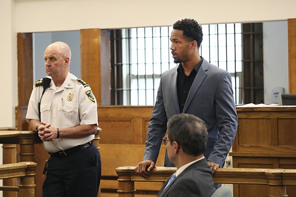 New England Patriots cornerback Jack Jones, rear right, is shown at his arraignment on gun charges at East Boston Municipal Court, Tuesday, June 20, 2023, in Boston, Mass. Jones was charged with carrying two loaded guns in his carry-on luggage at Logan Airport. (Suzanne Kreiter/The Boston Globe via AP, Pool)