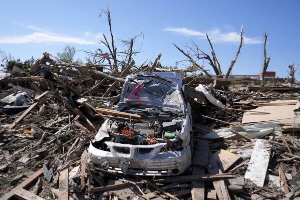 FILE - A tornado damaged car sits in a pile of debris, Thursday, May 23, 2024, in Greenfield, Iowa. Experts say that planning is key before a tornado threatens. They say weather radios, basements and bicycle helmets all save lives. Record warmth this winter provided the fuel for a deadly tornado outbreak across parts of the Midwest and South in March. (AP Photo/Charlie Neibergall, File)