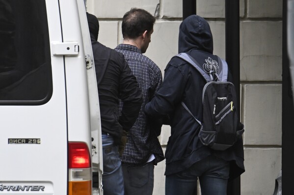Wall Street Journal reporter Evan Gershkovich, centre back to the camera, is escorted to the Lefortovsky court in Moscow, Russia, Thursday, Aug. 24, 2023. Gershkovich, who was detained on espionage charges, arrived at a Moscow court Thursday for a hearing on a motion by the prosecution to extend his arrest. (AP Photo/Dmitry Serebryakov)