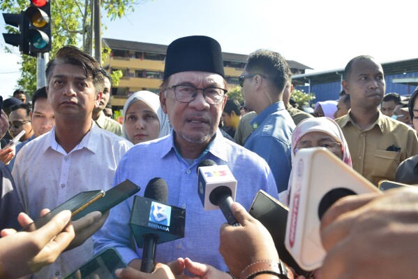 Malaysian Prime Minister Anwar Ibrahim, center, speaks to media after he cast his ballot during the election at a polling station in Seberang Perai, Penang state, Malaysia Saturday, Aug. 12, 2023. Voting began Saturday in crucial state elections in Malaysia, where Prime Minister Anwar Ibrahim's multi-coalition government is seeking to strengthen its hold against a strong Islamic opposition. (AP Photo/Vincent Thian)
