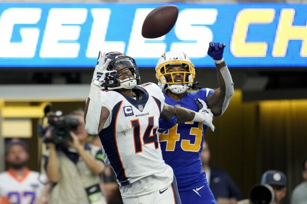 Denver Broncos wide receiver Courtland Sutton (14) reaches for a touchdown pass under pressure by Los Angeles Chargers cornerback Michael Davis (43) during the second half of an NFL football game Sunday, Dec. 10, 2023, in Inglewood, Calif. (AP Photo/Marcio Jose Sanchez)