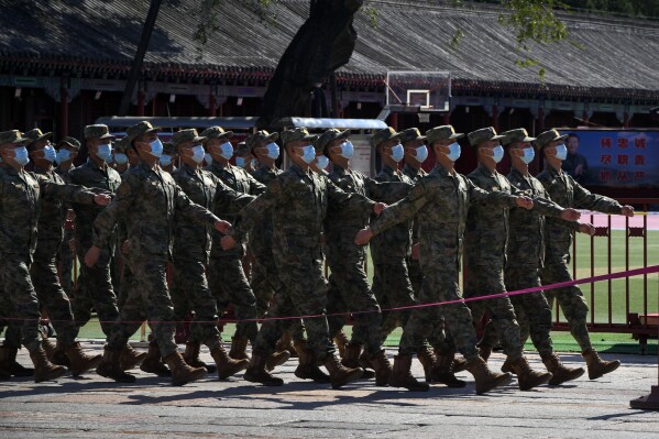 FILE - People's Liberation Army (PLA) soldiers march out from their quarters during the opening ceremony of the 20th National Congress of China's ruling Communist Party in Beijing, China, on Oct. 16, 2022. China has released a new documentary about the army’s preparation to attack Taiwan and showcasing soldiers pledging to give up their lives if needed as Beijing continues to ramp up its rhetoric against the self-ruled island. (AP Photo/Andy Wong, File)