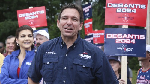 FILE - Republican presidential candidate and Florida Gov. Ron DeSantis and his wife Casey, walk in the July 4th parade, July 4, 2023, in Merrimack, NH DeSantis is defending an anti-LGBTQ video his campaign shared online that attacks rival Donald Trump for his past support of gay and transgender people, despite some of his fellow Republicans calling him homophobic. (AP Photo/Reba Saldanha, File)