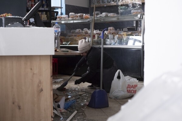 A woman cleans her shop after a Russian missile strike on Sumy, Ukraine, Sunday, April 13, 2025. (AP Photo/Volodymyr Hordiienko)