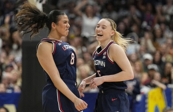 UConn center Jana El Alfy (8) and UConn guard Paige Bueckers (5) react during the first half of a national semifinal Final Four game against UCLA during the women's NCAA college basketball tournament, Friday, April 4, 2025, in Tampa, Fla. (AP Photo/Chris O'Meara)