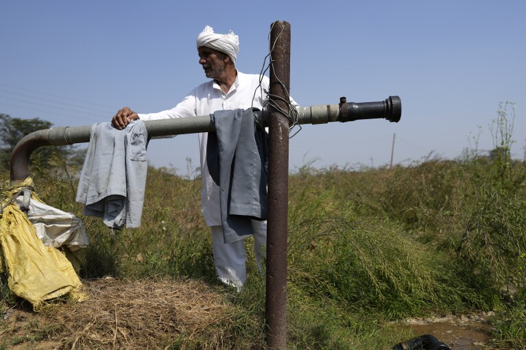 A farmer stands next to his well on the outskirts of Bawal, in the Indian state of Haryana, Thursday, March 7, 2024. (AP Photo/Manish Swarup)