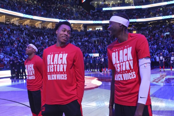 From left to right, Toronto Raptors forwards Bruce Brown, Scottie Barnes and Chris Boucher react as fans boo the United States national anthem before NBA basketball game action against the Los Angeles Clippers in Toronto, Sunday, Feb. 2, 2025. (Frank Gunn/The Canadian Press via AP)