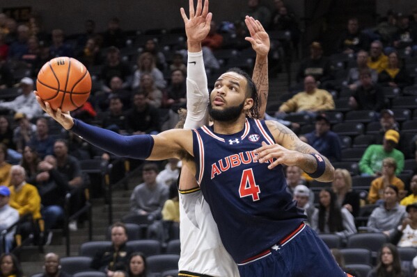FILE - Auburn's Johni Broome (4) shoots past Missouri's Noah Carter during the first half of an NCAA college basketball game Tuesday, March 5, 2024, in Columbia, Mo. (AP Photo/L.G. Patterson, File)