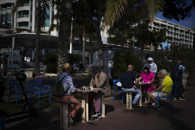 Pessoas jogam xadrez no Boulevard de la Croisette antes do 77º Festival Internacional de Cinema em Cannes, sul da França, segunda-feira, 13 de maio de 2024. O Festival de Cinema de Cannes acontece de 14 a 25 de maio de 2024. (AP Photo/Daniel Cole)