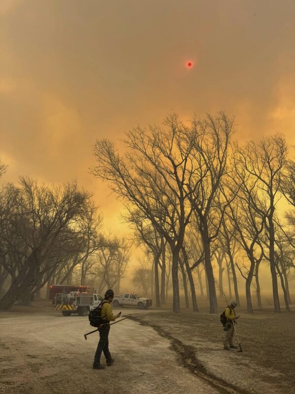 In this photo provided by the Flower Mound, Texas Fire Department, Flower Mound firefighters respond to a fire in the Texas Panhandle on Tuesday, February 27, 2024. A rapidly growing wildfire in Texas doubled in size on Tuesday, prompting evacuation orders for at least a year. A small town.  (Flower Mound Fire Department via AP)