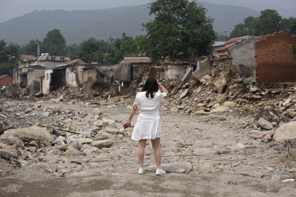 FILE - A woman reacts as she fails to find her house after flood waters devastate Nanxinfang village on the outskirts of Beijing, Friday, Aug. 4, 2023. Severe floods in China's northern province of Hebei brought by remnants of Typhoon Doksuri this month killed at least 29 people and caused billions of dollars in economic losses, its provincial government said Friday, Aug. 11, 2023. (AP Photo/Ng Han Guan, File)