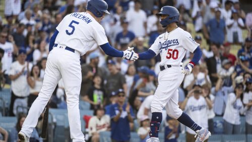 Los Angeles Dodgers' Mookie Betts (50), right, celebrates after his solo home run with Freddie Freeman (5) during the first inning of a baseball game against the Los Angeles Angels in Los Angeles, Saturday, July 8, 2023. (AP Photo/Kyusung Gong)
