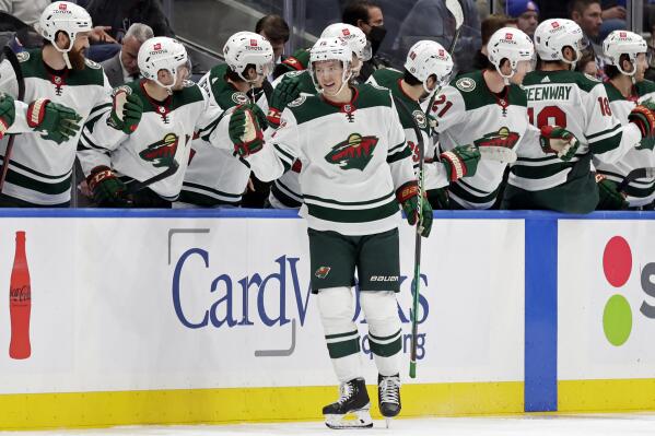 Minnesota Wild left wing Matt Boldy celebrates with teammates after scoring a goal in the second period of an NHL hockey game against the New York Islanders, Sunday, Jan. 30, 2022, in Elmont, N.Y. (AP Photo/Adam Hunger)