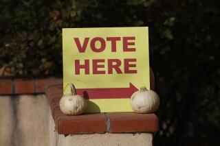 A sign directs voters to the entrance of a polling station at the St. John's United Methodist Church on Tuesday, Nov. 2, 2021, in Santa Fe, New Mexico. Voters cast ballots in municipal elections across the state, including for mayoral races and school funding measures. (AP Photo/Cedar Attanasio)