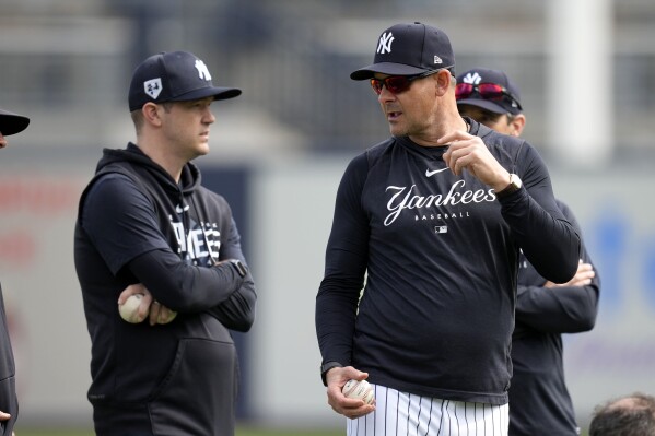 New York Yankees manager Aaron Boone talks with pitching coach Matt Blake, left, during a baseball spring training workout Thursday, Feb. 15, 2024, in Tampa, Fla. (AP Photo/Charlie Neibergall)