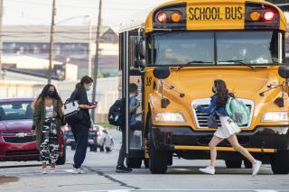 Students catch their bus near Ambridge Area Senior High School, Tuesday, Sept. 7, 2021, in Ambridge, Pa. Pennsylvania school districts will soon be allowed to modify or end the mask mandate for K-12 students in January, Gov. Tom Wolf announced Monday, Nov. 8, 2021 saying it is “time to prepare for a transition back to a more normal setting.” (Andrew Rush /Pittsburgh Post-Gazette via AP)