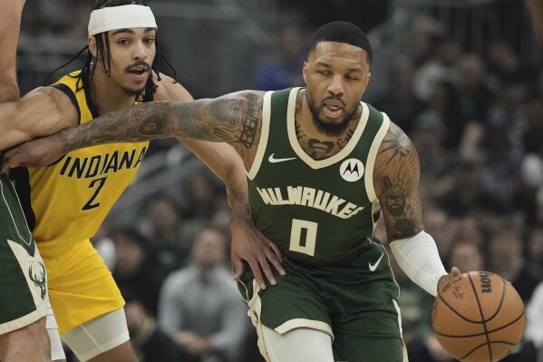 Milwaukee Bucks' Damian Lillard gets past Indiana Pacers' Andrew Nembhard during the first half of Game 1 of the NBA playoff basketball game Sunday, April 21, 2024, in Milwaukee. (AP Photo/Morry Gash)