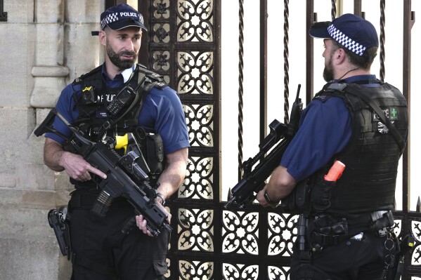 Police officers stand guard outside the Houses of Parliament in London, Monday, Sept. 25, 2023. The head of London's police force is calling for increased legal protections for officers who use force in the line of duty after more than 100 officers refused to carry guns to protest murder charges filed against one of their colleagues. (AP Photo/Kin Cheung)