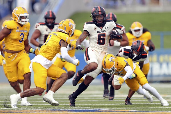 Oregon State's Damien Martinez rushes between San Jose State's Jay'Vion Cole (8) and Chase Williams (1) during the first half of an NCAA college football game in San Jose, Calif., on Sunday, Sept. 3, 2023. (Scott Strazzante/San Francisco Chronicle via AP)