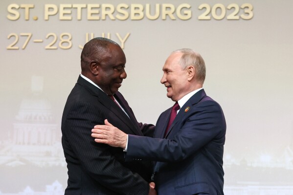 FILE - President of the Republic of South Africa Cyril Ramaphosa, left, and Russian President Vladimir Putin shake hands before an official ceremony to welcome the leaders of delegations to the Russia Africa Summit in St. Petersburg, Russia, Thursday, July 27, 2023. Russia and China will look to gain more political and economic ground in the developing world at a summit of the BRICS bloc in South Africa this week. Putin will take part in the main summit on Wednesday, Aug. 23, 2023 via video link after an International Criminal Court arrest warrant complicated his travel to South Africa. (Sergei Bobylev/TASS Host Photo Agency Pool Photo via AP, File)