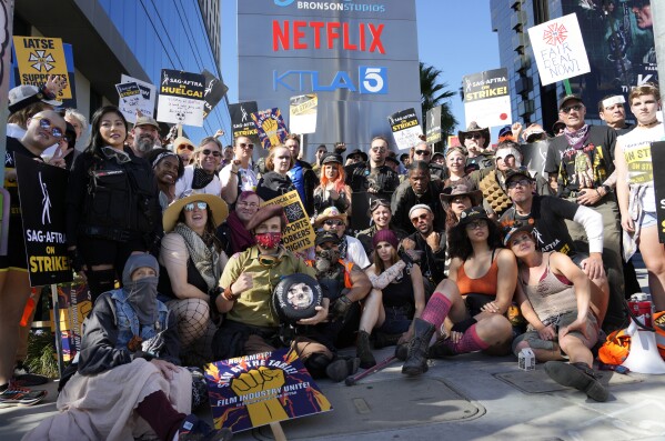 Striking SAG-AFTRA members pose for a group photo on a post apocalyptic-themed picket line outside Netflix studios, Wednesday, Nov. 8, 2023, in Los Angeles. (AP Photo/Chris Pizzello)