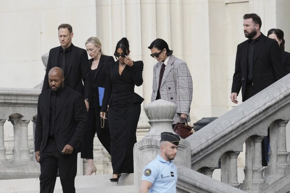 Kim Kardashian, center left, accompanied by her mother Kris Jenner, center right, leaves the justice palace after testifying, regarding a robbery of millions of dollars in jewels from her Paris hotel room in 2016, in Paris, Tuesday, May 13, 2025. (AP Photo/Aurelien Morissard)