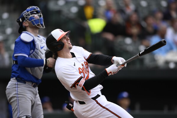 Baltimore Orioles' Adley Rutschman, right, watches his walk-off two-run home run in front of Toronto Blue Jays catcher Danny Jansen, left, during the ninth inning of a baseball game against the Toronto Blue Jays, Wednesday, May 15, 2024, in Baltimore. The home run was reviewed and upheld. The Orioles won 3-2. (AP Photo/Nick Wass)