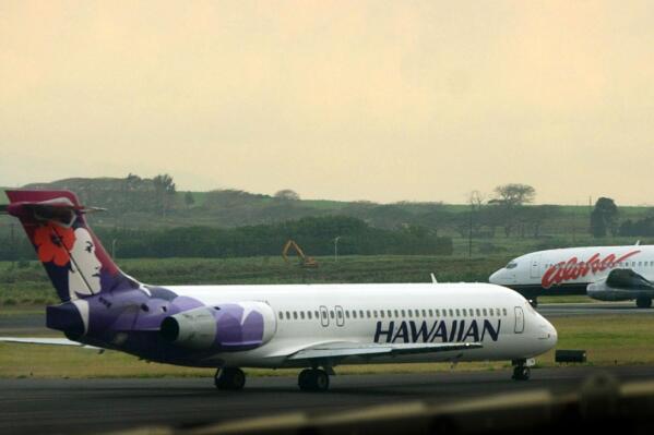 FILE - An Hawaiian Airlines plane taxis for position at Kahalui, Hawaii on the island of Maui on March 24, 2005. Hawaiian Airlines will operate 10 cargo planes for Amazon.com starting next fall under a deal that could eventually involve more planes and give Amazon a 15% stake in the airline, the airline’s parent company, Hawaiian Holdings Inc., said Friday, Oct. 21, 2022.  (AP Photo/Lucy Pemoni, FIle)