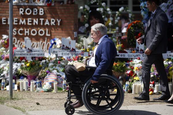 FILE - Texas Gov. Greg Abbott passes in front of a memorial outside Robb Elementary School to honor the victims killed in a school shooting in Uvalde, Texas, May 29, 2022.  In the aftermath of the school shooting in Uvalde, Texas, governors around the country vowed to take steps to ensure their students would be kept safe. Months later, as students return to classrooms, money has begun to flow for school security upgrades, training and other new efforts to make classrooms safer.  (AP Photo/Dario Lopez-Mills, File)