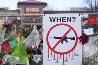 FILE - Tributes hang on the temporary fence surrounding the parking lot in front of a King Soopers grocery store in which 10 people died in a late March mass shooting, Friday, April 9, 2021, in Boulder, Colo. A federal judge has temporarily blocked the town of Superior, Colo., from enforcing parts of a new gun control ordinance, including a ban on the sale and possession of assault weapons, in a lawsuit brought by the Rocky Mountain Gun Owners, the National Association for Gun Rights and a Superior resident. (AP Photo/David Zalubowski, File)