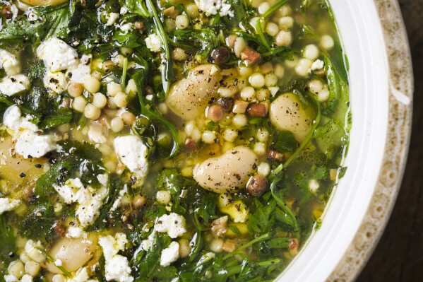 This image released by Milk Street shows a recipe for Sardinian herb soup with fregola and white beans. (Milk Street via AP)