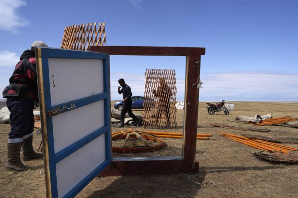 Family members of herder Lkhaebum erect their ger, a portable, round tent insulated with sheepskin, upon arrival at a new pasture in the Munkh-Khaan region of the Sukhbaatar district in southeast Mongolia, Sunday, May 15, 2023. (AP Photo/Manish Swarup)