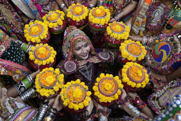 Indians in traditional attire pose for the media as they practice the Garba, a traditional dance of Gujarat state, ahead of Navratri festival in Ahmedabad, India, Monday, Oct. 9, 2023. The Hindu festival of Navratri, or nine nights, will begin on October 15. (AP Photo/Ajit Solanki)