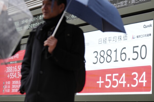 A person stands in front of an electronic stock board showing Japan's Nikkei 225 index at a securities firm Thursday, Feb. 22, 2024, in Tokyo. Japan’s Nikkei 225 share index surged briefly to an all-time high on Thursday, bypassing its previous record set in December 1989.(AP Photo/Eugene Hoshiko)