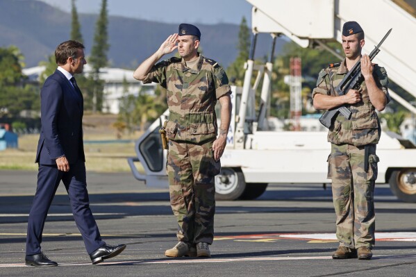French President Emmanuel Macron inspects a guard of honor on his arrival at Noumea ñ La Tontouta International airport, in Noumea, New Caledonia, Thursday, May 23, 2024. Macron has landed in riot-hit New Caledonia, having crossed the globe by plane from Paris in a high-profile show of support for the French Pacific archipelago wracked by deadly unrest and where indigenous people have long sought independence from France. (Ludovic Marin/Pool Photo via AP)