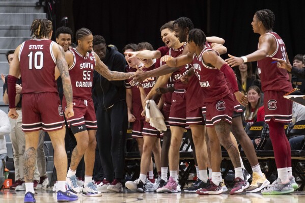 South Carolina's Ta'Lon Cooper (55) is congratulated by teammates after scoring the tying basket in regulation during the second half of an NCAA college basketball game against Missouri Saturday, Jan. 13, 2024, in Columbia, Mo. South Carolina won 71-69 in overtime. (AP Photo/L.G. Patterson)