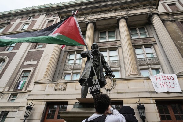 FILE - A student protester parades a Palestinian flag outside the entrance to Hamilton Hall on the campus of Columbia University, Tuesday, April 30, 2024, in New York. The student-run legal journal, Columbia Law Review, was taken offline Monday, June 3, 2024, after its board of directors objected to the publication of an article that accused Israel of genocide. (AP Photo/Mary Altaffer, Pool, File)