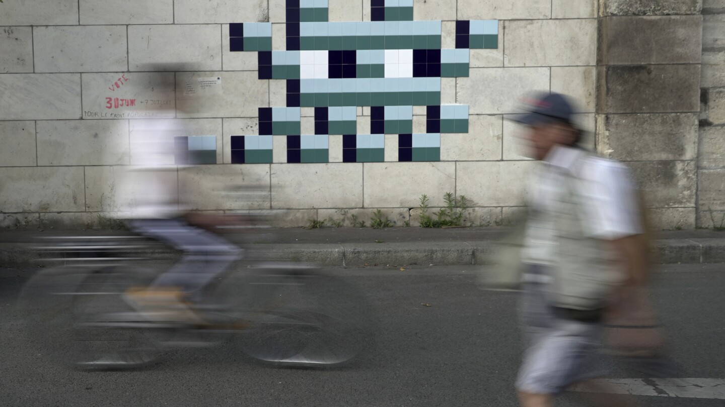 Mystery Paris street artist 'Invader' glues up new work to celebrate Olympics and delight fans