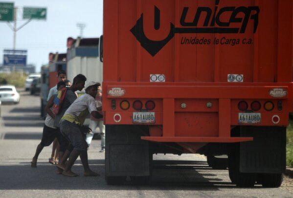 
              In this Jan. 23, 2018 photo, men try to steal rice from a cargo truck arriving to the port in Puerto Cabello, Venezuela. Sporadic looting, food riots and protests driven by hunger have surged in Venezuela, a country that's no stranger to unrest. (AP Photo/Fernando Llano)
            
