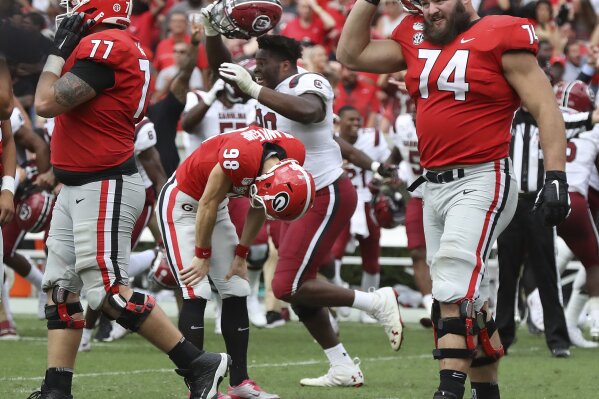 Georgia kicker Rodrigo Blankenship (98) bends over dejected reacting to missing a field goal attempt in double over time as South Carolina celebrates a 20-17 upset victory  in an NCAA college football game, Saturday, Oct., 12, 2019, in Athens, Ga. (Curtis Compton/Atlanta Journal-Constitution via AP)